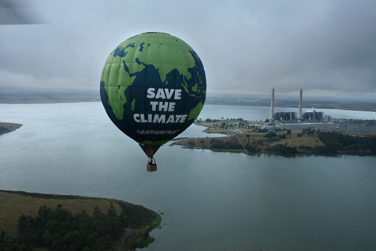 Un globo aerostático sobrevuela una central térmica en Australia con el mensaje Save the Climate