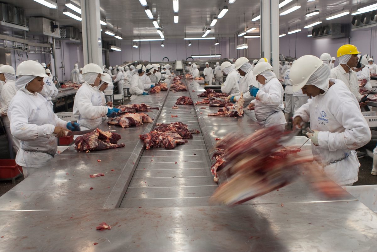 Un grupo de trabajadores procesa carne de vacuno en una fábrica de Brasil