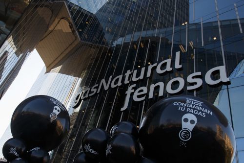 Activistas de Greenpeace sostienen globos en los que se puede leer 'Ellos contaminan tú pagas' frente a la sede de Gas Natural Fenosa en Barcelona