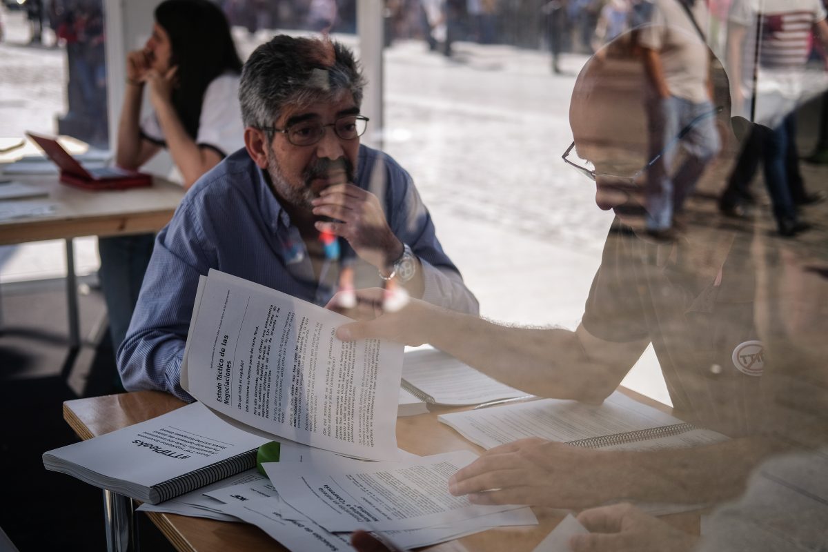 Varias personas consultan documentos filtrados a Greenpeace sobre el TTIP. El 21/05/2016. en la Puerta del Sol, Madrid