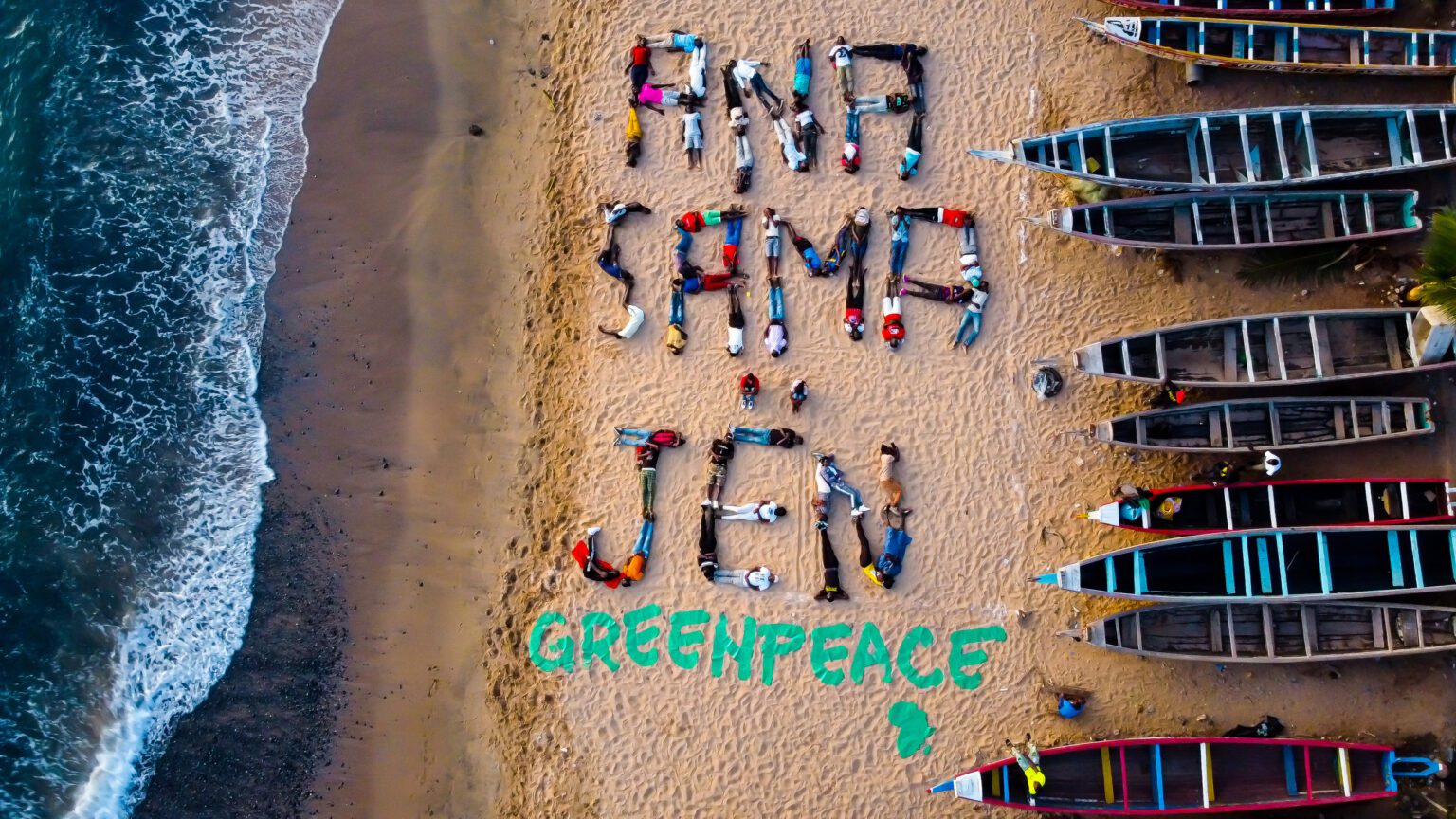 Miembros de una comunidad pesquera en Senegal se unen a un artista local para crear una pancarta humana que dice “Ana Sama Jën” (“¿Dónde está mi pescado?”). © Mbaye Ndir / Greenpeace