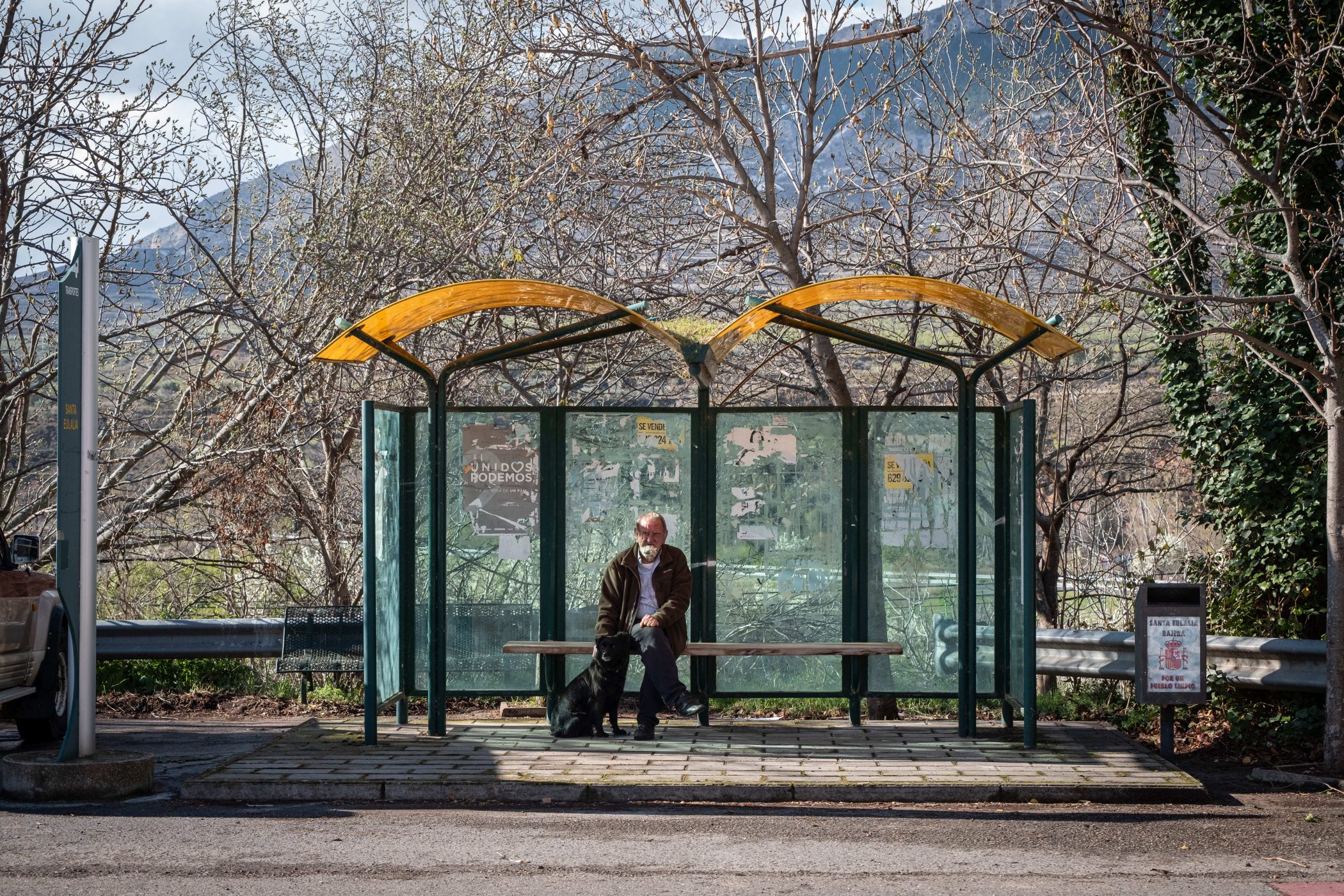 Un hombre espera el autobús en una parada solitaria