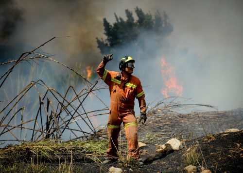 Un bombero da indicaciones mientras tratan de apagar las llamas del fuego en el incendio de Montserrat, en las proximidades de Valencia